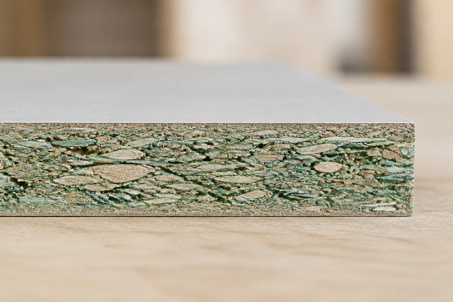 Moisture-resistant cabinet board showing a green-dyed particleboard core
